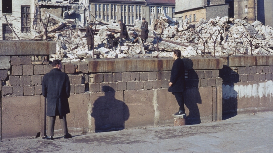 West-Berliner vis à vis mit Grenzsoldaten auf den Trümmern eines Grenzhauses 