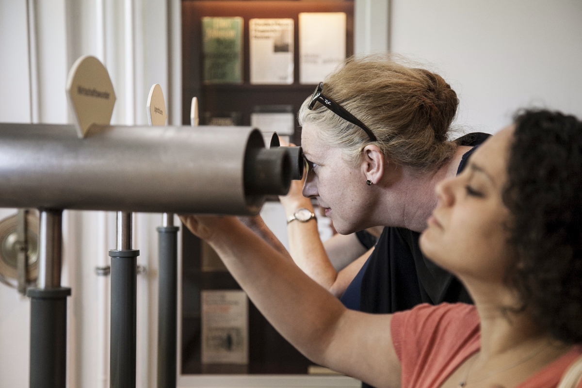 Frau guckt durch Fernrohr 
