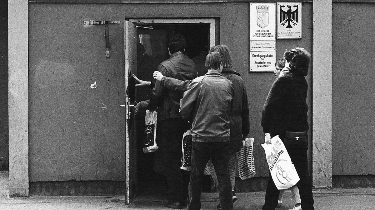 Ankommende gehen durch eine Tür hinein in das Durchgangsheim