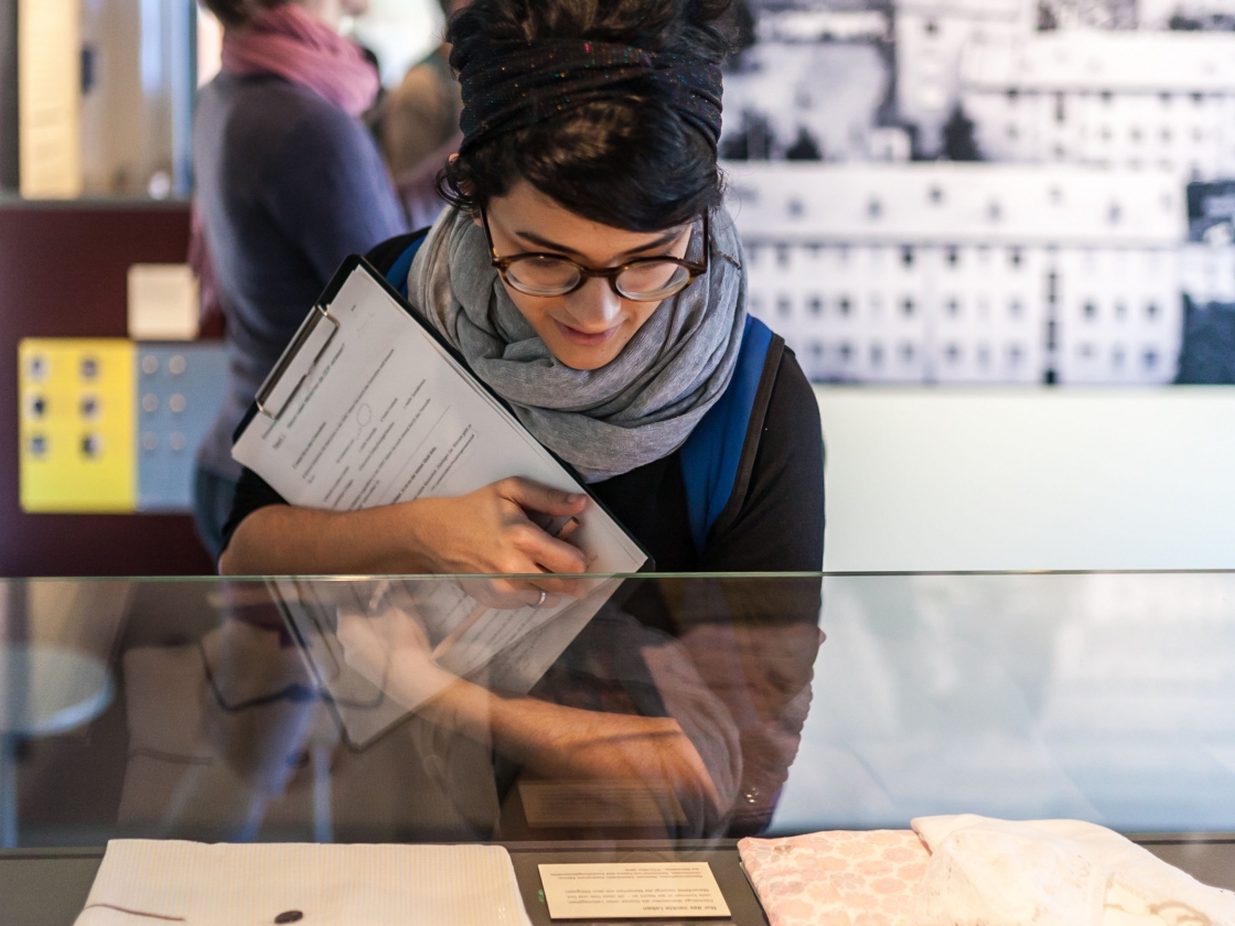 Junge Frau schaut in Vitrine